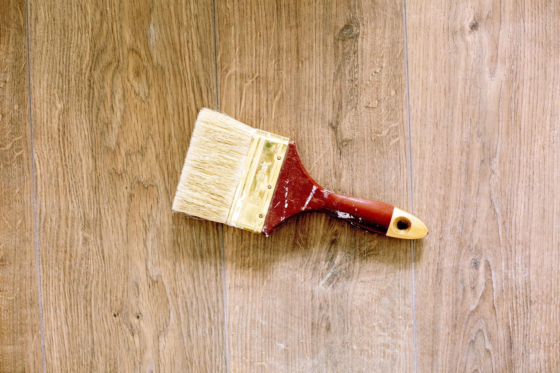 A paint brush to be use for painting wood is planted on a wooden surface in a commercial space in Hobart TAS.